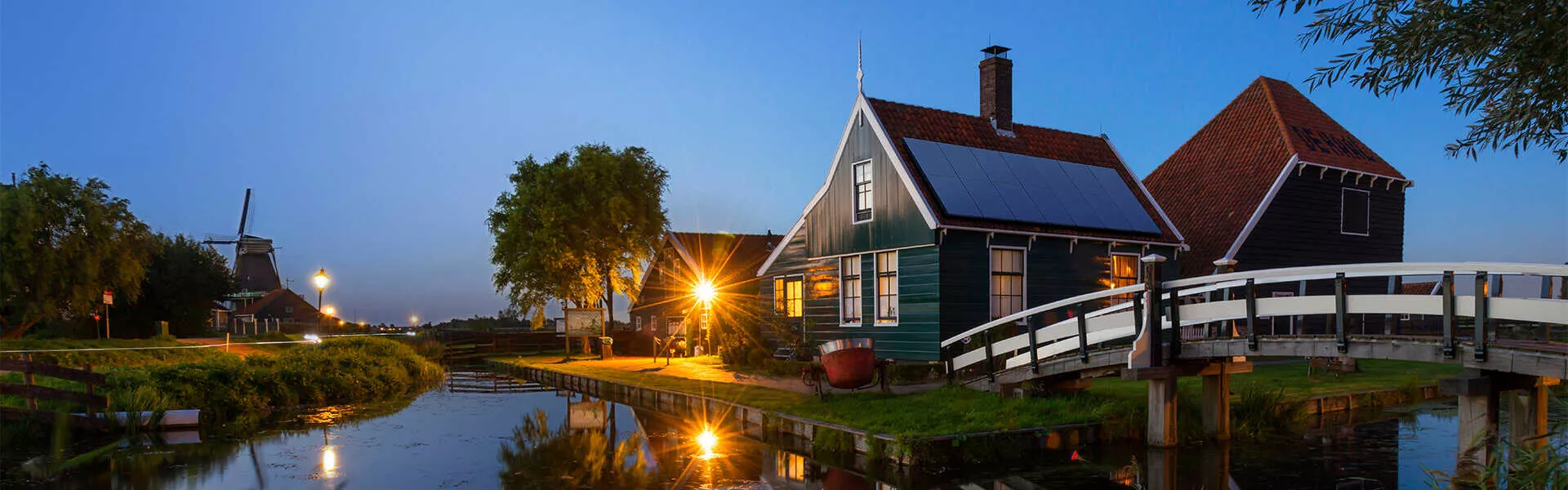 home with solar panels next to canal